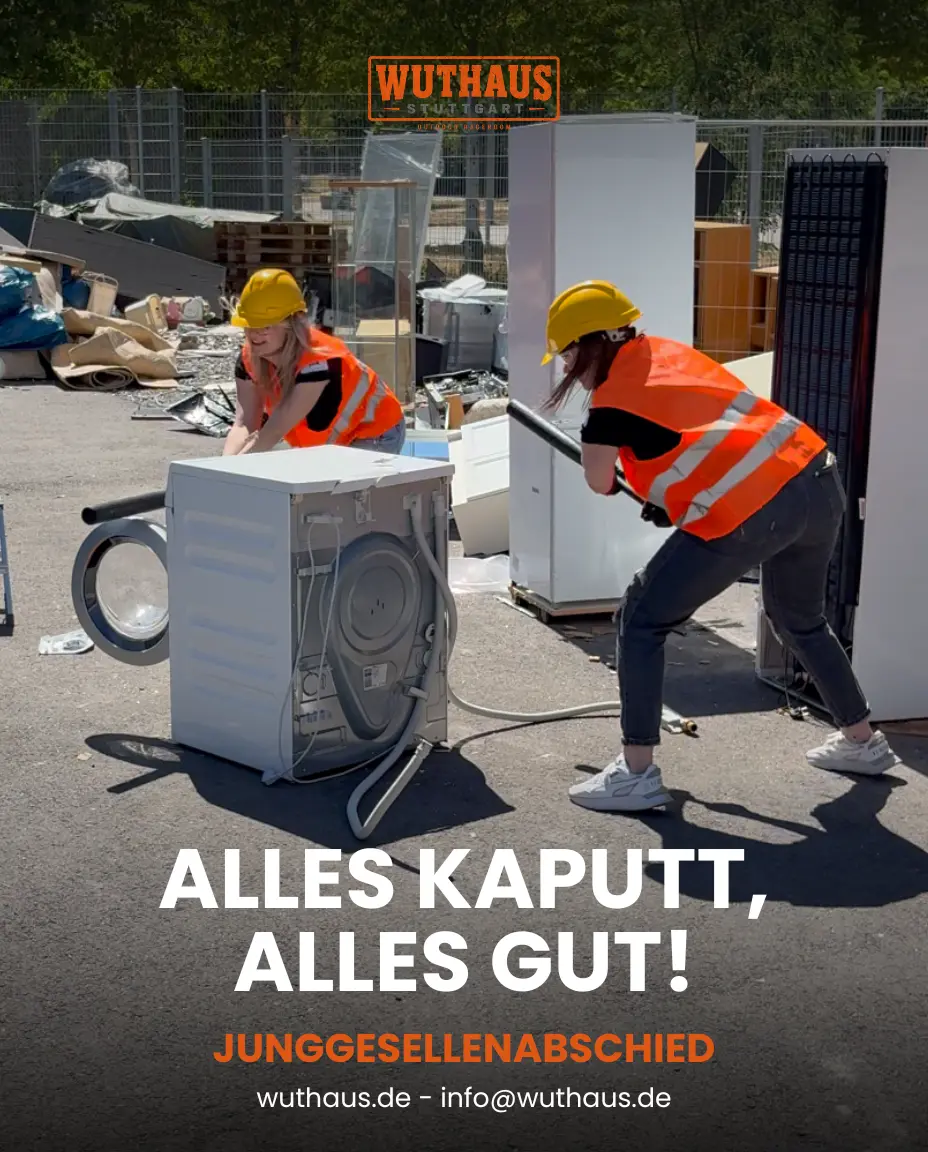 Zwei Frauen schlagen auf eine Waschmaschine ein im Wuthaus Rageroom Stuttgart